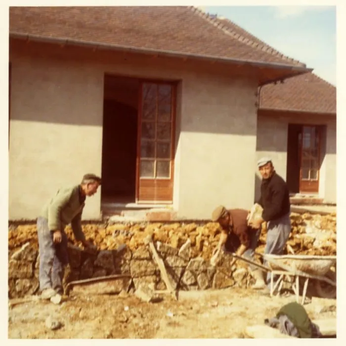 Maçons au travail devant une maison en 1975