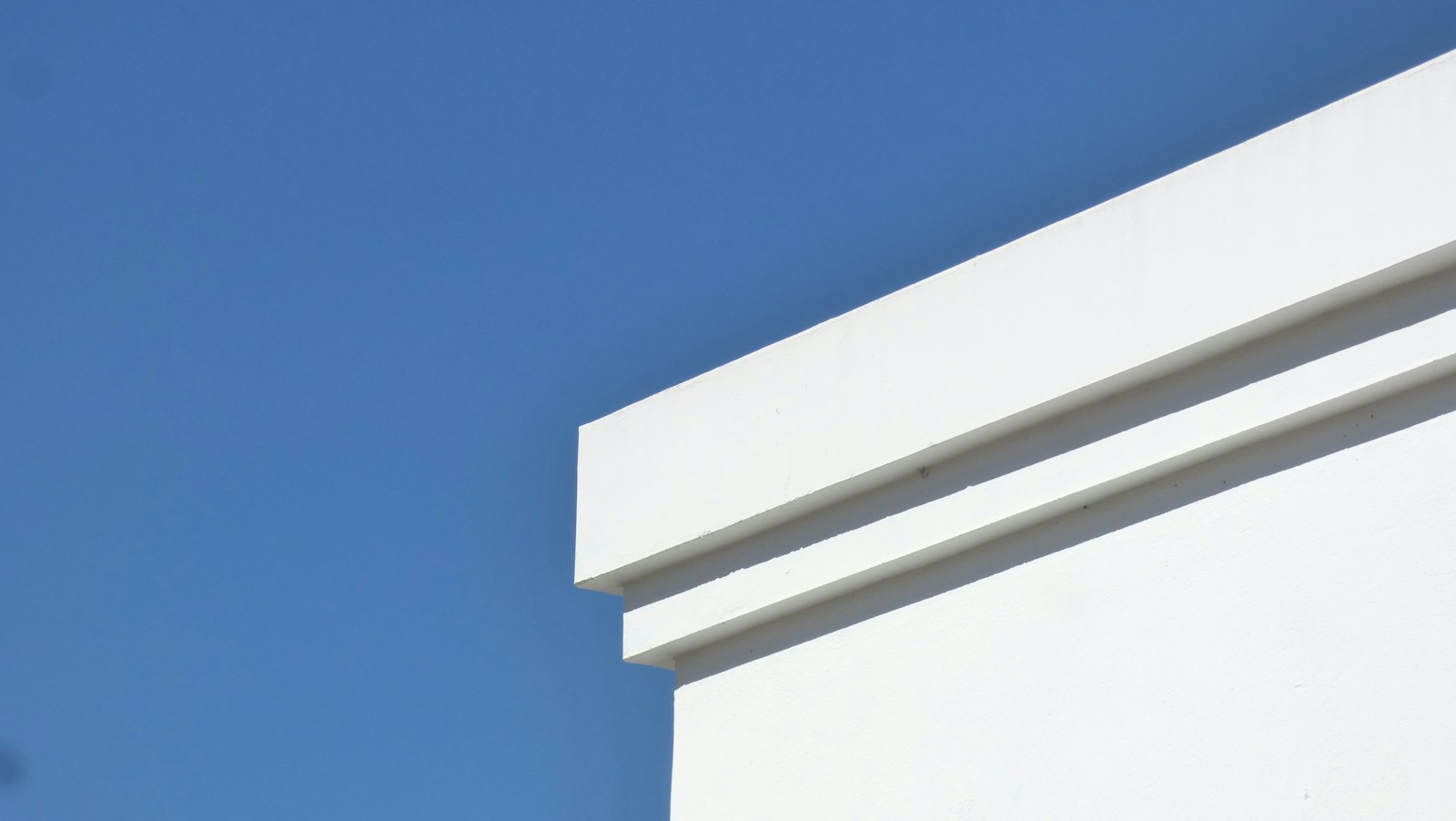 Angle de façade blanche découpé sur un ciel bleu
