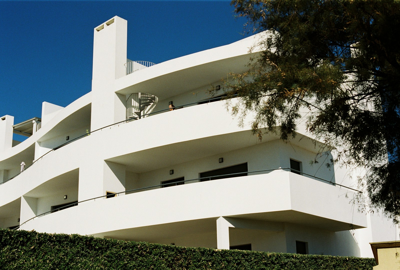 Immeuble de logements blanc aux balcons courbes sous un ciel bleu